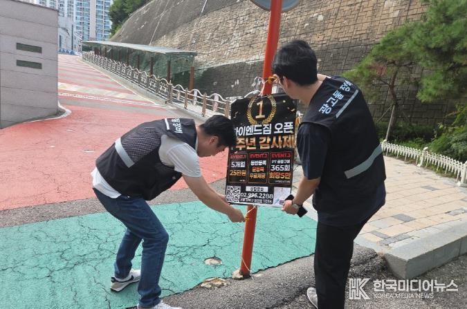 강북구 점검반이 초등학교 앞 불법광고물을 정비하고 있다.