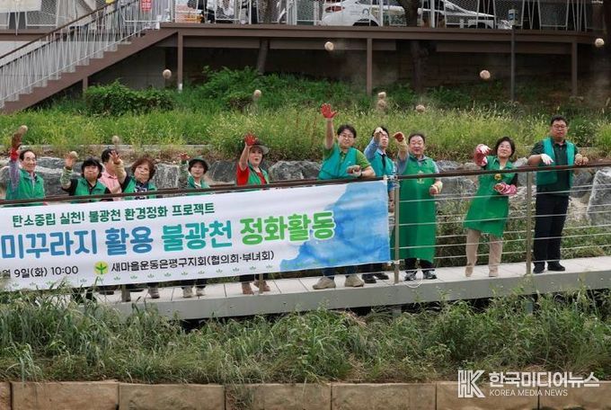 불광천에 흙 공을 던지고 있는 새마을운동 은평지구회와 김미경 구청장(오른쪽 두 번째)