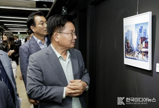 박강수 마포구청장이 레드로드 발전소 갤러리에 전시된 작품을 감상하고 있다.
