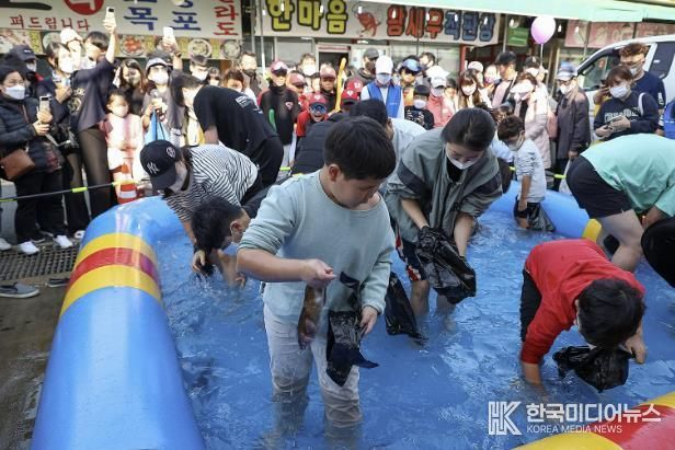 제10회 시흥월곶포구축제 중 맨손 고기잡이 체험에 참여 중인 시민들