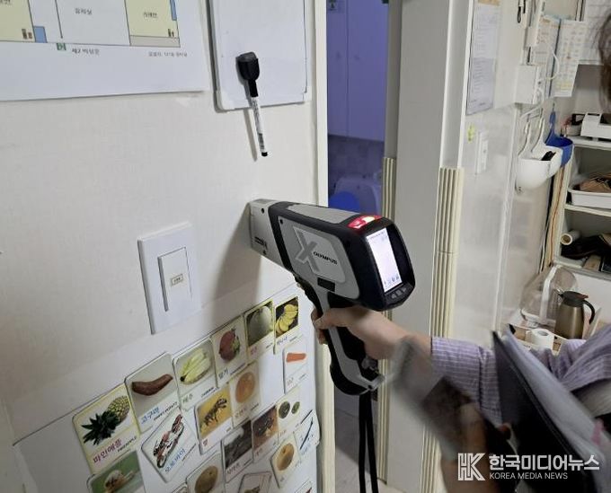 구청 관계자가 어린이집 실내 벽에 사용된 도료의 중금속 함량을 측정하고 있다