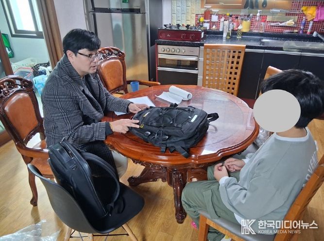 신안군 드림스타트 아동통합사례관리사가 가정 방문하여 아동에게 책가방을 전달하고 있다.