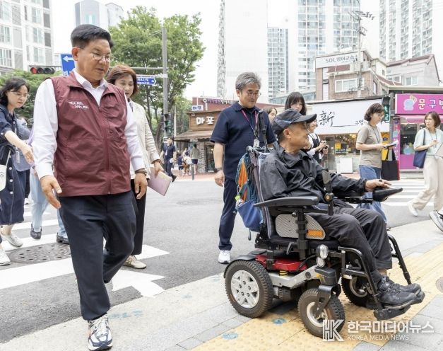 박강수 마포구청장이 휠체어를 탄 주민과 함께 새로 조성된 무장애길을 걷고 있다.