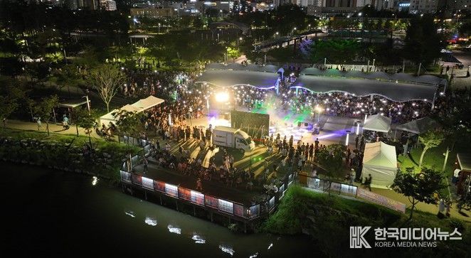 미사호수공원 계단광장을 가득 메운 시민들이 자유로운 분위기 속에서 버스킹 공연을 관람하며 일상의 즐거움을 만끽하고 있다. 사진은 2025년 하반기 오픈 공연 현장